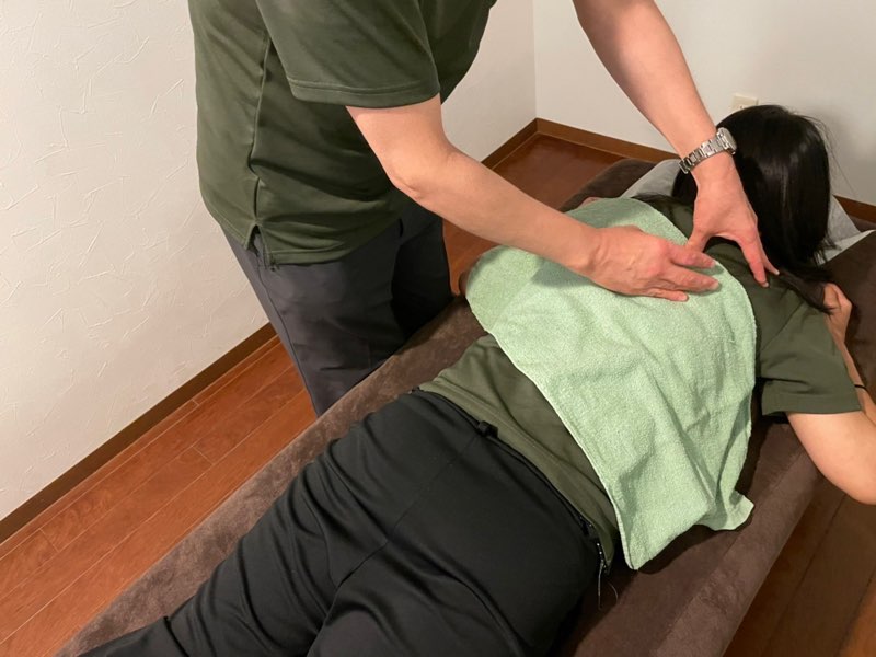 背中を揉んでもらっている人